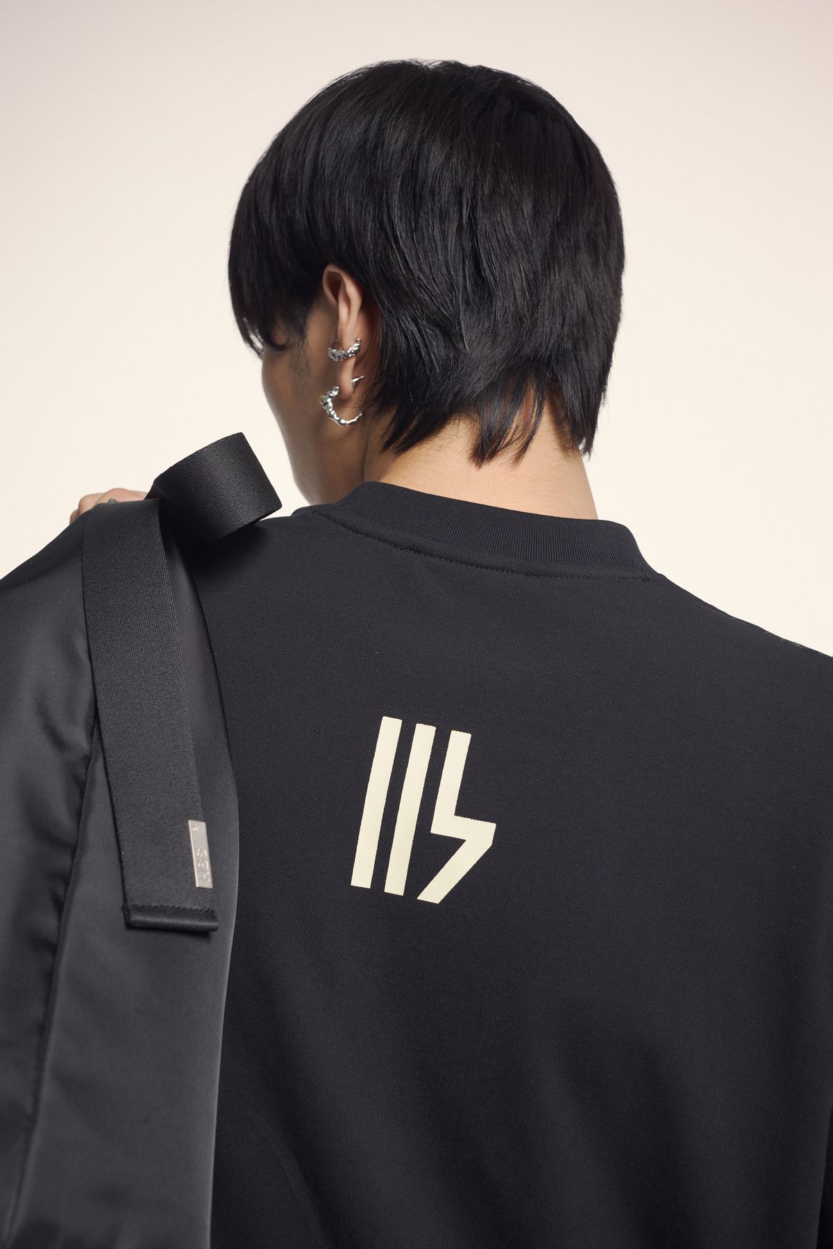 Lưng áo đen in logo HBS màu kem